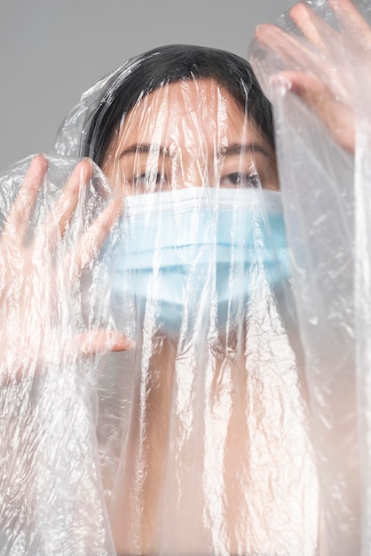 Free Photo | Young woman with medical mask being covered in plastic