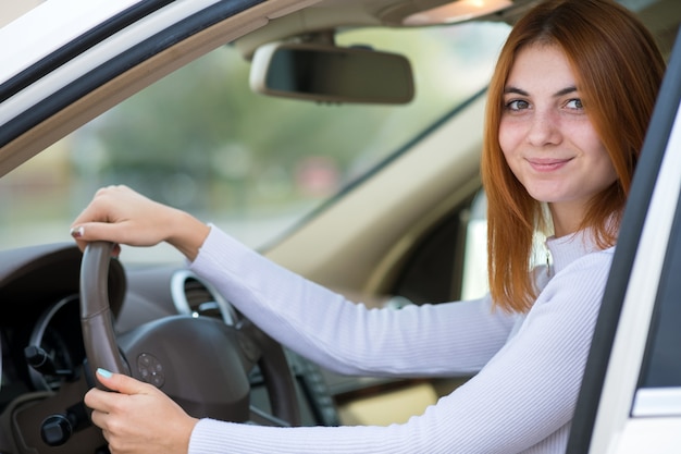 Premium Photo | Young woman with red hair driving a car.