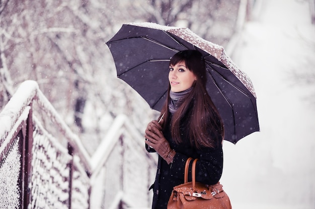 Premium Photo | Young woman with umbrella in snowfall, retro toned image