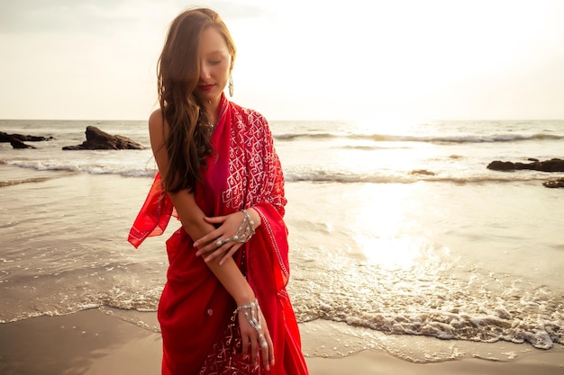 Premium Photo | Young women wearing a red saree on the beach goa india ...