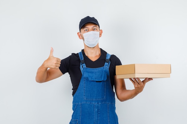 Download Free Photo | Young worker holding cardboard box with thumb ...