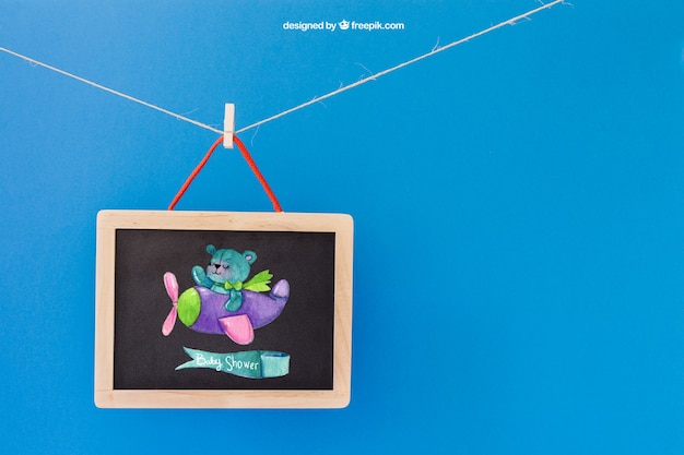 Download Free PSD | Baby mockup with slate hanging on clothes peg