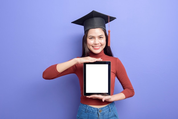 Download Beautiful woman in graduation cap is holding tablet mockup ...