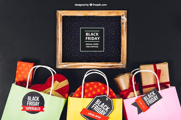 Download Black friday mockup with slate and bags full of presents ...
