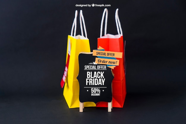 Download Black friday mockup with two bags behind board | Free PSD File