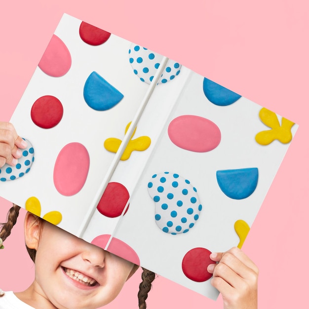 Download Free PSD | Book cover mockup psd with plasticine clay pattern holding by a girl