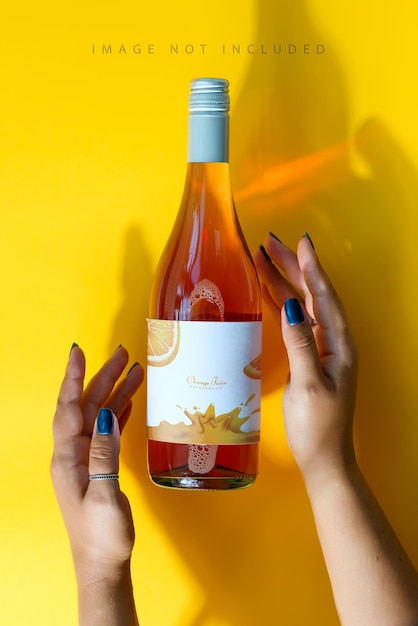 Download Premium PSD | A bottle of rose wine in female hands with a mockup
