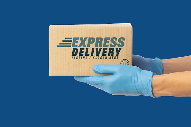 Download Closeup deliveryman's hand in medical gloves holding cardboard box mockup | Premium PSD File