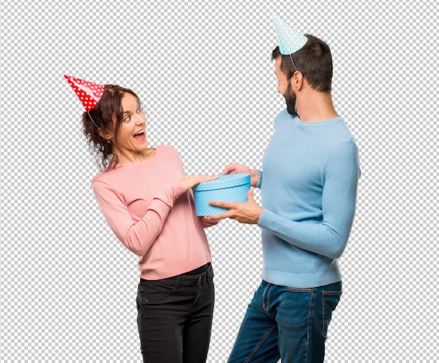 Download Couple with birthday hats and holding a gifts | Premium PSD File