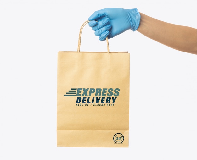 Download Delivery man hand holding craft paper shopping bag mockup template | Premium PSD File