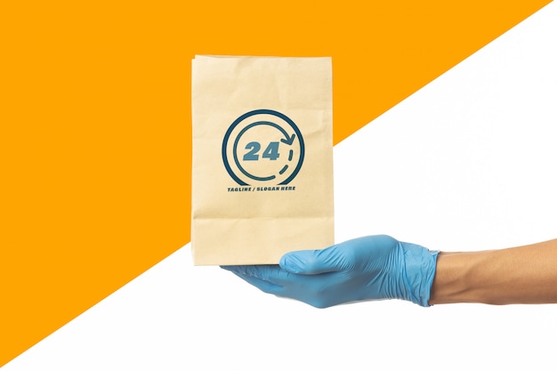 Download Delivery man hand holding food paper bag mockup template | Premium PSD File