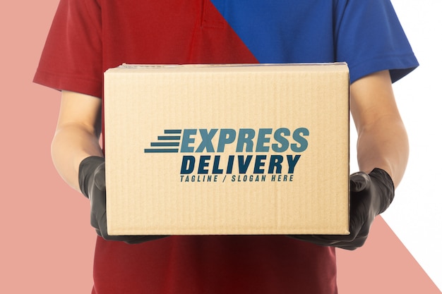 Download Delivery man hand in medical gloves holding blank cardboard box mockup template. | Premium PSD File