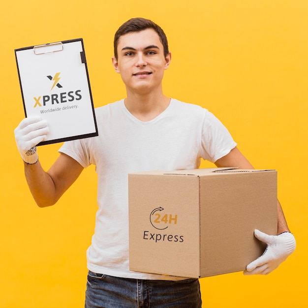 Download Delivery man holding parcel and clipboard mock-up | Free PSD File