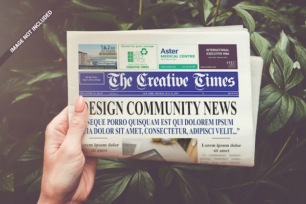 Download Folded newspaper in hand mockup | Premium PSD File