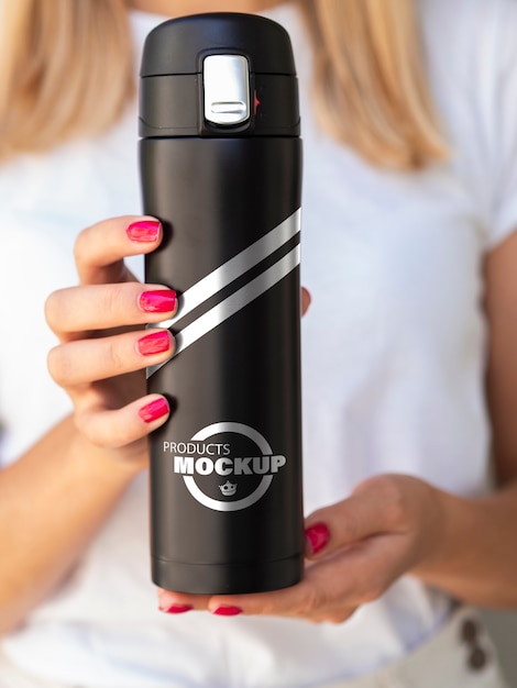 Download Front view woman holding a black thermos mock-up | Free PSD File