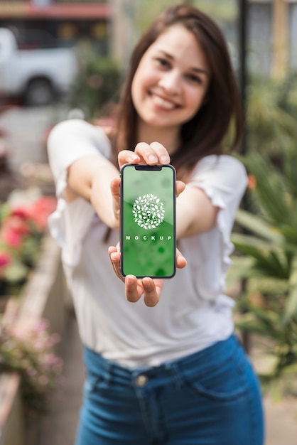 Download Girl holding smartphone mockup with gardening concept ...