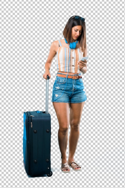 Girl traveling with her suitcase sending a message or email with the mobile Premium Psd