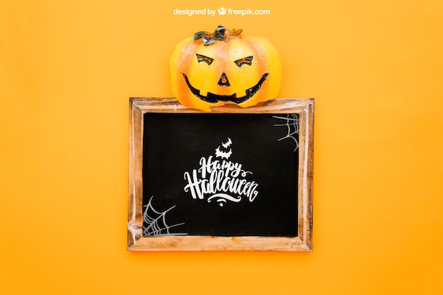 Download Free PSD | Halloween mockup with pumpkin op top of slate