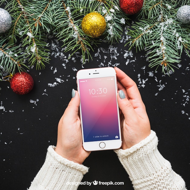 Download Hand holding smartphone mockup with christmas design | Free PSD File