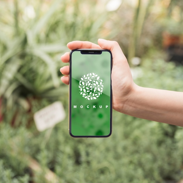 Download Hand holding smartphone mockup with gardening concept ... PSD Mockup Templates