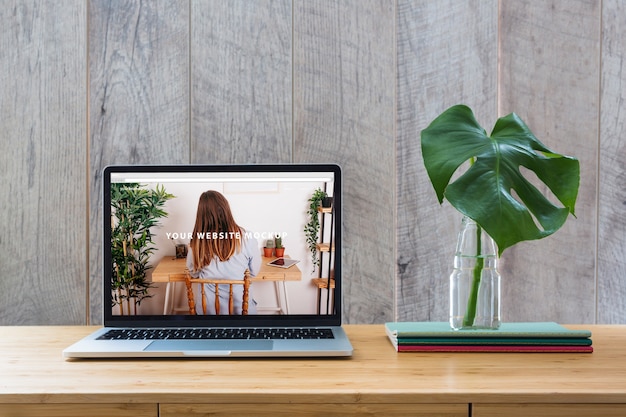 Download Laptop mockup on table with plants | Free PSD File