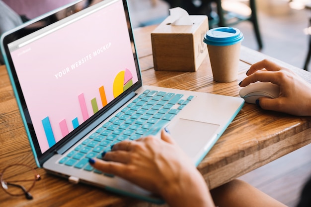 Download Laptop mockup with woman on wooden table | Free PSD File