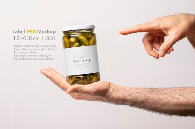 Download Premium PSD | Male hands pointing a pickled cucumber glass jar mockup