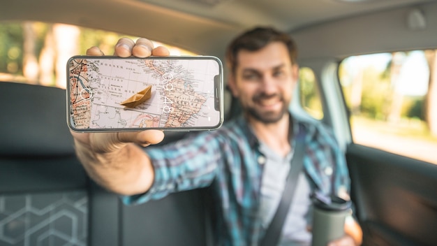 Man in car showing smartphone mockup PSD Template