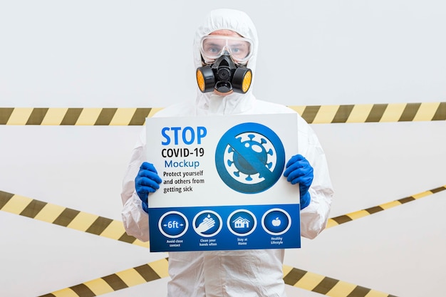 Download Man in hazmat suit holding a stop coronavirus mock-up ...