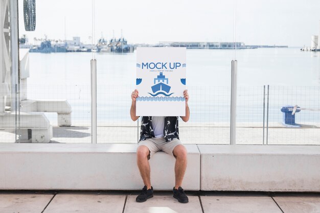 Download Man holding poster mockup in harbor | Free PSD File