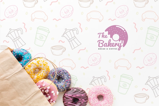 Download Free PSD | Mix of colorful donuts in paper bag with mock-up