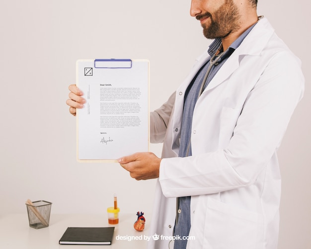 Download Mock up design with smiley doctor holding clipboard PSD ...