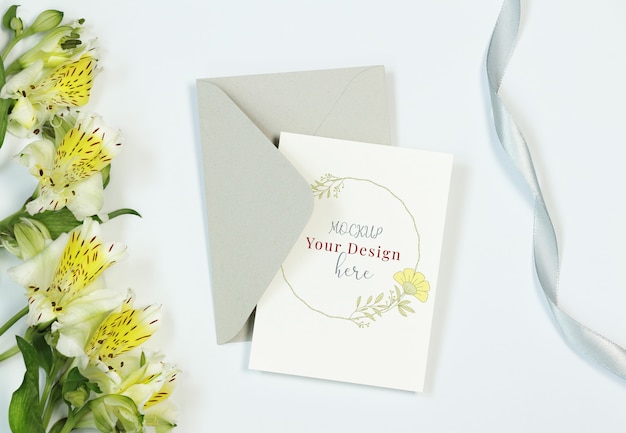 Mockup invitation card on white background with flowers, envelope and ribbon Premium Psd