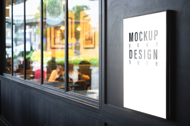 Download Premium PSD | Mockup lightbox on the black wall with blurred restaurant background.