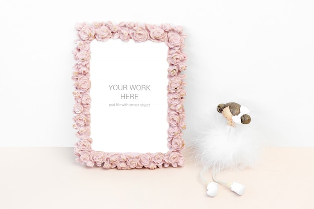 Mockup photo frame with pink rose flower and statuette ...