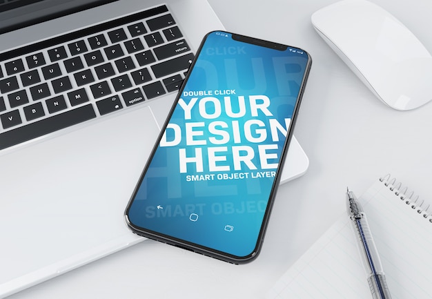 Modern smartphone laying on a laptop mockup PSD file