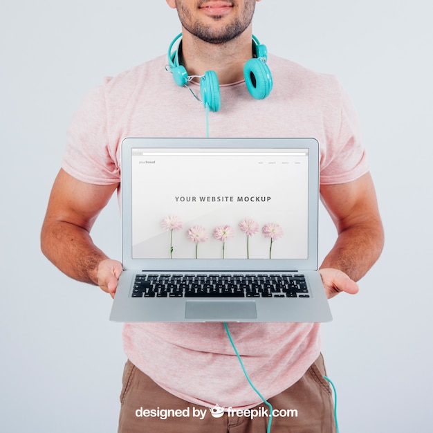 Modern young guy holding laptop's mock up PSD Template