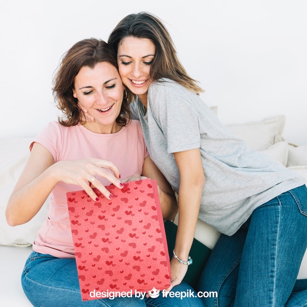 Mothers day mockup with daughter and mother looking into bag PSD Template