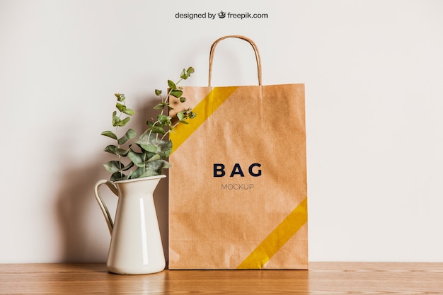 Download Free PSD | Paper bag mockup next to flower pot