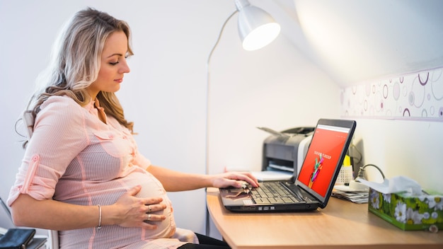 Pregnant woman using laptop PSD Template