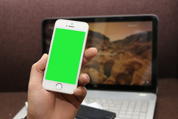 Smartphone with green screen and a laptop PSD Template