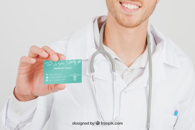 Download Free PSD | Smiley doctor with mock up of visit card