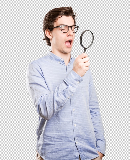 Download Surprised young man using a magnifying glass | Premium PSD File