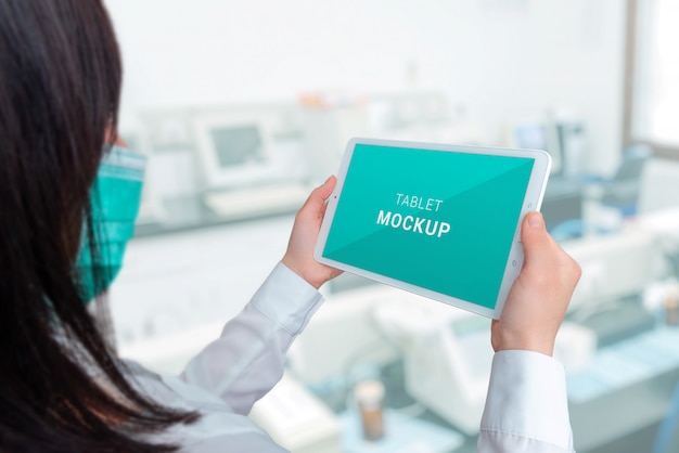 Download Tablet mockup in the hands of a specialist. hospital laboratory in background | Premium PSD File