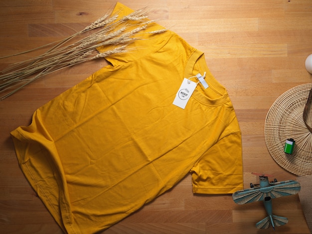 Download Premium PSD | Top view of mock up yellow t-shirt with mock up price tag on wooden table with ...