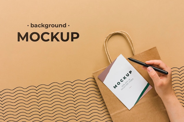 Download Premium PSD | Top view paper bag mock-up and hand