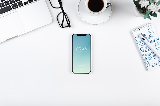 Top view smartphone mockup on workspace Free Psd