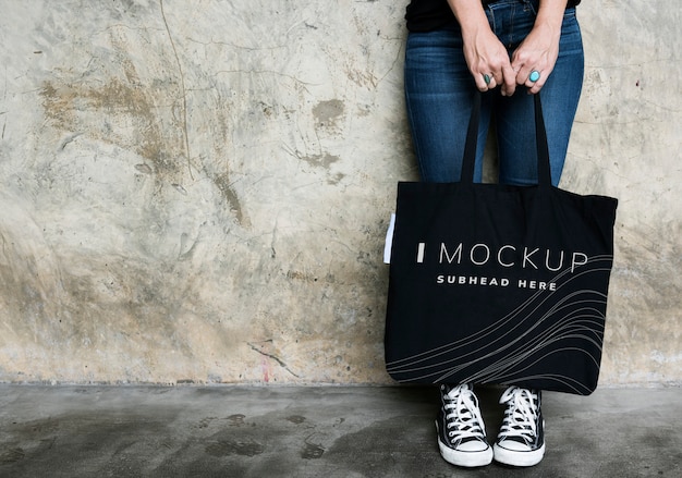 Woman carrying a black tote bag mockup PSD Template