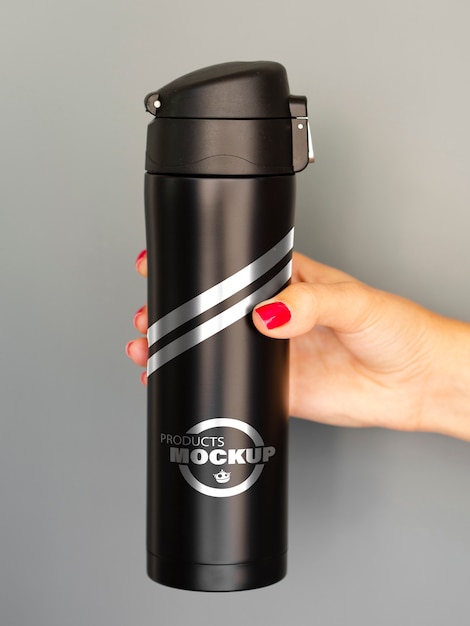 Woman holding a black thermos mock-up | Free PSD File