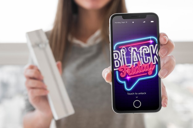 Download Woman holding smartphone mockup with black friday concept ...